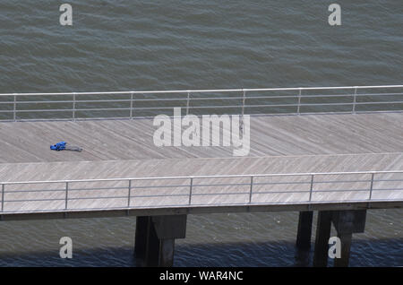 SAISON DE COULÉE : les cannes à pêche s'appuient sur la balustrade d'une jetée vide de promenade à Atlantic City, NJ, au large de la baie d'Absecon. Banque D'Images