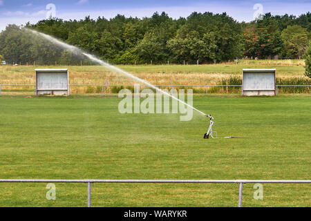 Sprinkler Watering Terrain de football. Le système fonctionne sur l'herbe verte fraîche sur le football ou soccer Stadium Banque D'Images