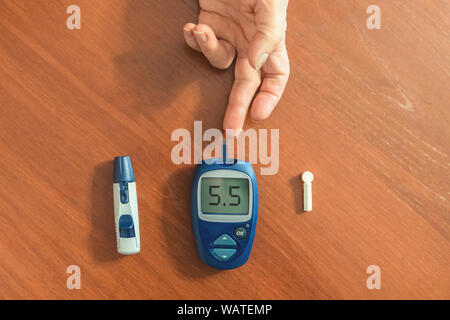 Test patient diabétique hypoglycémique son sang pour le sucre à la maison niveau bas sucre de sang. Processus médical, s'auto-diagnostiquer, métabolique commun, répandu Banque D'Images