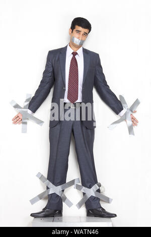 Businessman collée au mur avec du ruban adhésif Banque D'Images
