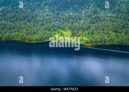 Petite maison indépendante dans l'Teletskoe Lake à l'Altaï près du lac entouré d'arbres verts sur une journée ensoleillée Banque D'Images