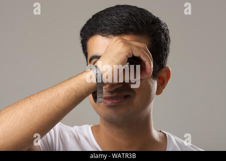 Portrait d'un jeune homme à l'aide de doigts que des lunettes Banque D'Images