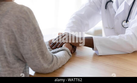 Black male doctor holding hands de patiente, vue rapprochée Banque D'Images