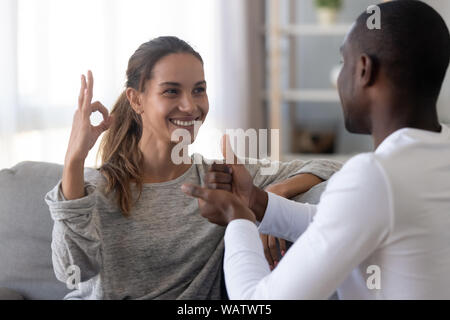 Happy mixed race couple sourds utilisant la langue des signes pour la communication Banque D'Images