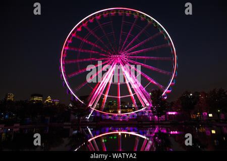 Grande roue illuminée dans le Vieux-Port de Montréal. L'exposition longue scène de nuit avec le flou sur la roue et la réflexion, avec le moderne Banque D'Images