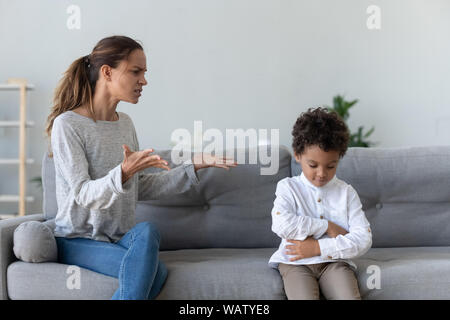 Agacé maman les réprimandes des conférences de l'Afrique de l'obstinée kid fils à la maison Banque D'Images