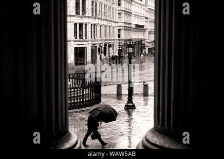 L'homme sous le parapluie est sous la pluie près de la cathédrale St Pauls Banque D'Images