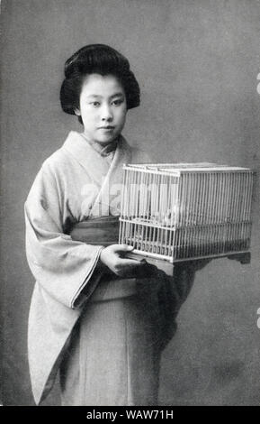 [ 1910 - Japon femme japonaise avec cage à oiseaux ] - femme en kimono tenant une cage à oiseaux. 20e siècle vintage carte postale. Banque D'Images