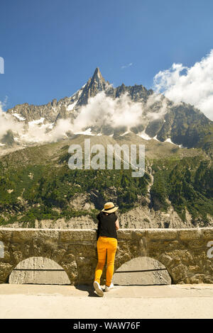 Un touriste de derrière à admirer la vue des aiguilles du Dru, une montagne dans le massif du Mont Blanc, dans les Alpes françaises, Montenvers, Chamonix, France Banque D'Images