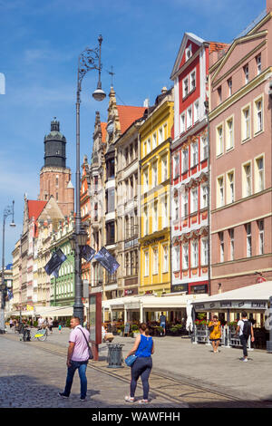 Les gens et les touristes vacanciers touristes visiteurs dans les ruelles pavées, place du marché de la ville polonaise de Wroclaw Pologne avec ses bâtiments colorés Banque D'Images