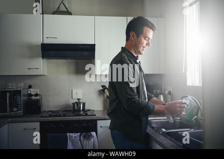 Homme heureux de nettoyer le verre avec éponge Banque D'Images