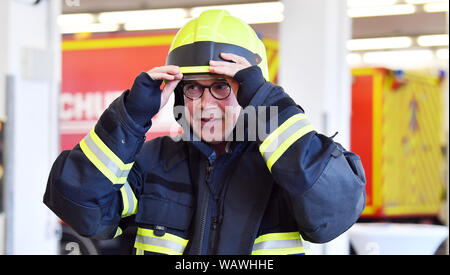 Zella Mehlis, Allemagne. Août 22, 2019. Georg Maier (SPD), le ministre de l'intérieur de la Thuringe, porte un uniforme de pompiers pour aider à sauver une personne d'un véhicule dans le centre de prévention du danger Zella-Mehlis. Auparavant, il avait présenté le rapport 2018 Fire et de catastrophe lors d'une conférence de presse. Crédit : Martin Schutt/dpa-Zentralbild/dpa/Alamy Live News Banque D'Images