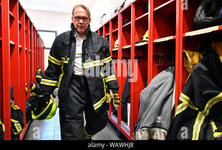 Zella Mehlis, Allemagne. Août 22, 2019. Georg Maier (SPD), le ministre de l'intérieur de la Thuringe, porte un uniforme de pompiers pour aider à sauver une personne d'un véhicule dans le centre de prévention du danger Zella-Mehlis. Auparavant, il avait présenté le rapport 2018 Fire et de catastrophe lors d'une conférence de presse. Crédit : Martin Schutt/dpa-Zentralbild/dpa/Alamy Live News Banque D'Images