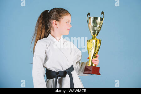 Petit enfant fille en kimono blanc avec ceinture. Karate fighter enfant. Karate sport concept. Compétences d'auto-défense. Le karaté donne un sentiment de confiance. De souligner leurs réalisations. Kid forte et confiante. Banque D'Images