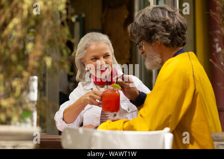 Heureux couple marié smoothie potable dans le café. Banque D'Images