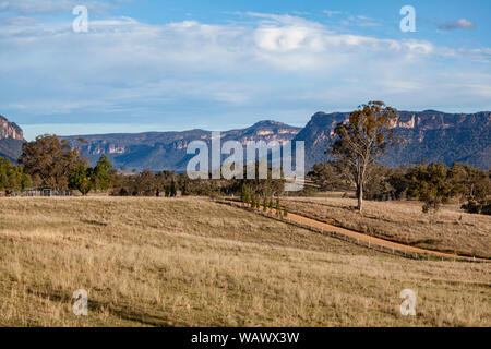 Les plaines herbeuses soutenu par le bush naturel robuste et crêtes de grès dans la vallée Capertee, NSW, Australie Banque D'Images