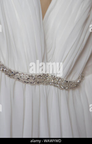 Close up of robe de mariage avec des paillettes d'argent autour de la taille, sur un jour de mariage, mariage robe est de raccrocher en attente d'être porté Banque D'Images