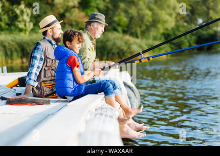 Les hommes de trois générations tous ensemble de pêche Banque D'Images