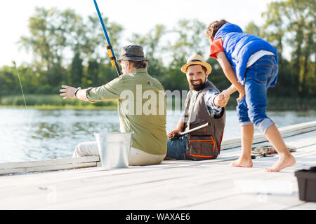 Les hommes se sentir heureux tout en ayant la pêche en famille Banque D'Images