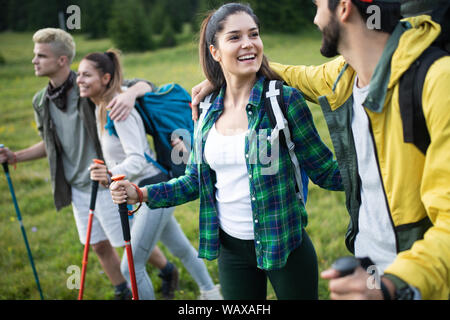 Groupe d'amis sont la randonnée en montagne. Les jeunes gens marchant à travers la campagne. Banque D'Images