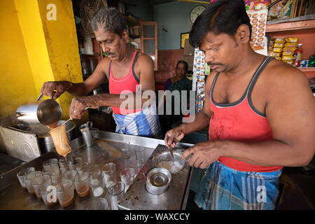 Plateau wallah la préparation du thé dans un petit stand traditionnel à Madurai, Inde. Banque D'Images