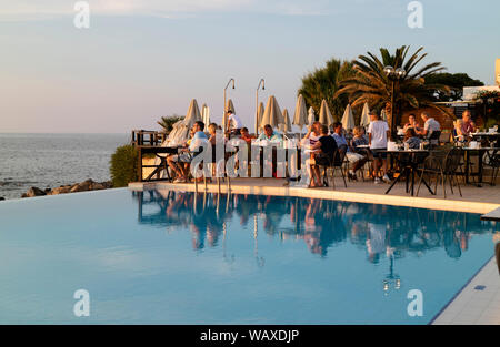 Crète, Grèce. Vous pourrez manger autour d'une piscine de l'hôtel près de coucher du soleil. Banque D'Images