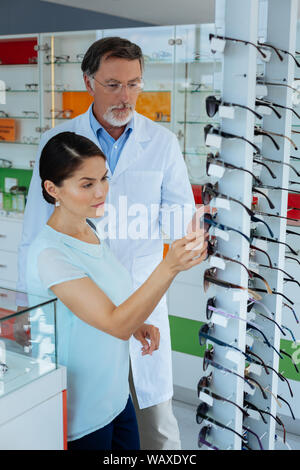 Opticien professionnel aidant à choisir lunettes Banque D'Images