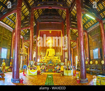 CHIANG MAI, THAÏLANDE - Mai 2, 2019 : Intérieur de Wat Phan Tao temple, construit de bois foncé avec de hauts piliers, murs et plafond modeste, golden Banque D'Images