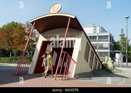 Les gens qui entrent dans l'inhabituelle entrée de la station de métro Bockenheimer Warte - où un tramway semble éclater de depuis le sol - Francfort, Allemagne Banque D'Images