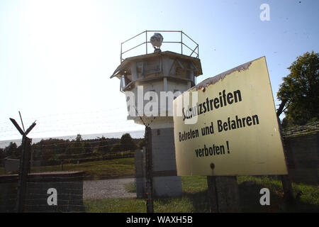 22 août 2019, la Thuringe, Mödlareuth : un panneau d'avertissement se trouve en face d'une ancienne tour d'observation à l'Grenzlandmuseum. Pendant 41 ans, à l'intérieur de la frontière allemande a couru jusqu'au milieu du village de Mödlareuth, qui est donc aussi appelé 'Petit Berlin'. Photo : Bodo/Schackow Zentralbild-dpa/afp Banque D'Images