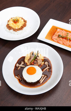 Porc épicé japonais Tan Tan sur du riz, salade de saumon tataki et hamburger steak avec des oeufs au plat et de champignon. Vue de dessus shot Banque D'Images