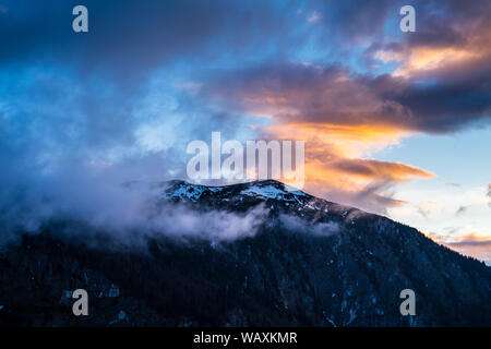 Le Monténégro, le pic enneigé du durmitor montagnes cachées par le brouillard et les nuages rouges en atmosphère aube magique au coucher du soleil sur le sommet du mont cu Banque D'Images