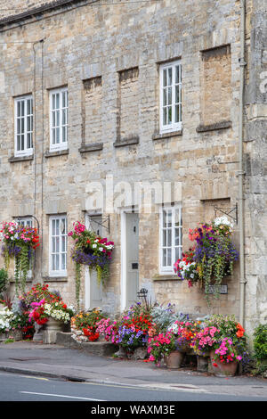 Paniers suspendus floral fleurs et des jardinières à l'extérieur de la tontine édifices le long de la colline, Cecily Cirencester, Cotswolds, Gloucestershire, Angleterre Banque D'Images