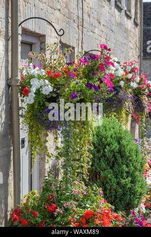 Paniers suspendus floral fleurs et des jardinières à l'extérieur de la tontine édifices le long de la colline, Cecily Cirencester, Cotswolds, Gloucestershire, Angleterre Banque D'Images