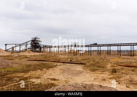 Paysage industriel désert avec rusty stationnaire séparateur gravitationnelle de sable et de gravier à l'horizon Banque D'Images