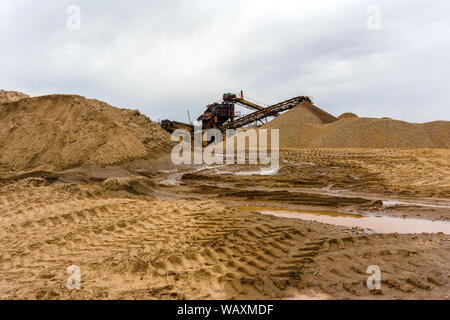 Paysage industriel désert avec rusty stationnaire séparateur gravitationnelle de sable et de gravier à l'horizon Banque D'Images