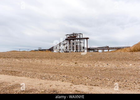 Paysage industriel désert avec rusty stationnaire séparateur gravitationnelle de sable et de gravier à l'horizon Banque D'Images