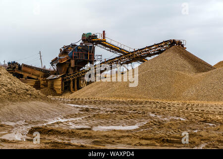 Paysage industriel désert avec rusty stationnaire séparateur gravitationnelle de sable et de gravier à l'horizon Banque D'Images