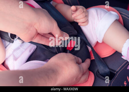 Le processus de la fixation des ceintures de sécurité sur un siège pour enfant dans la voiture. Sécurité pour les enfants, la sécurité des transports Banque D'Images