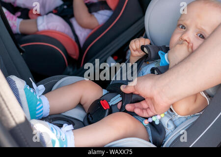 Le processus de la fixation des ceintures de sécurité sur un siège pour enfant dans la voiture. Sécurité pour les enfants, la sécurité des transports Banque D'Images