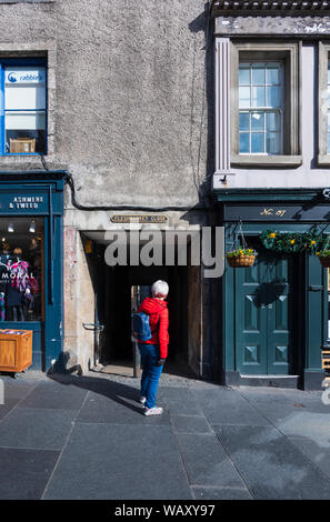 Touriste à la recherche dans une allée sombre Fleshmarket Close off the Royal Mile à Édimbourg. L'emplacement célèbre d'un roman de Ian Rankin Rebus crime. Banque D'Images