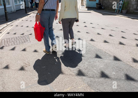 Deux personnes d'ombres tout en faisant du shopping à Falmouth, Cornwall, UK Banque D'Images