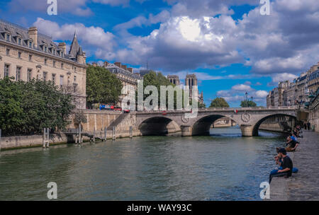 Les quais de Seine, Paris, France - 30 juillet 2018 : voir au bas de la Cathédrale Notre Dame des tours et pont traversant la Seine à partir d'un dock avec peo Banque D'Images