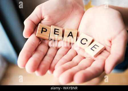 Le mot paix est écrit en lettres cubes dans les mains, selective focus. Banque D'Images