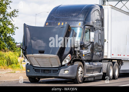 American Classic Noir bonnet gros camion semi truck avec capot ouvert debout sur le bord de la route pour l'attente d'un remorquage mobile pour réparer le moteur et schedul Banque D'Images