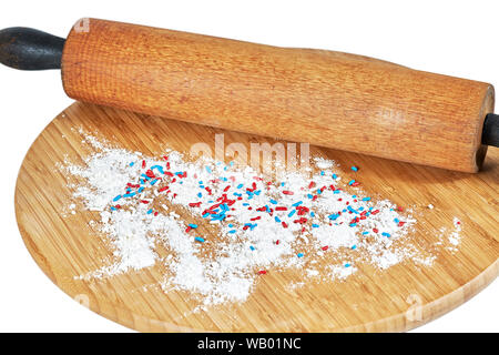 Un rouleau à pâtisserie en bois sur une planche à découper en bambou avec de la farine blanche et multicolore arrose au conseil isolated on white Banque D'Images