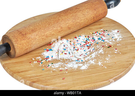 Un rouleau à pâtisserie en bois sur une planche à découper en bambou avec de la farine blanche et multicolore arrose au conseil isolated on white Banque D'Images