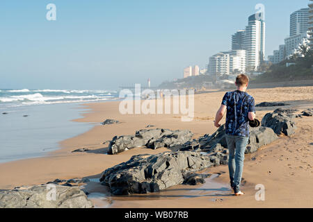 DURBAN, AFRIQUE DU SUD - le 22 août 2019 : l'homme marchant sur la plage à Umhlanga Rocks, près de Durban, le KwaZulu-Natal, Afrique du Sud Banque D'Images