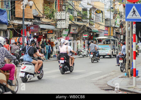 Les gens sont à cheval sur les motos à leurs destinations à Hanoi, Vietnam. Banque D'Images