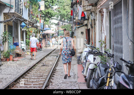 Une femme marche sur le chemin de fer en train street, Hanoi, Vietnam Banque D'Images